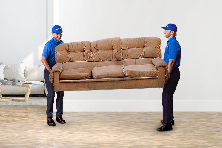 1-800-GOT-JUNK? truck team removing an old brown couch from a home