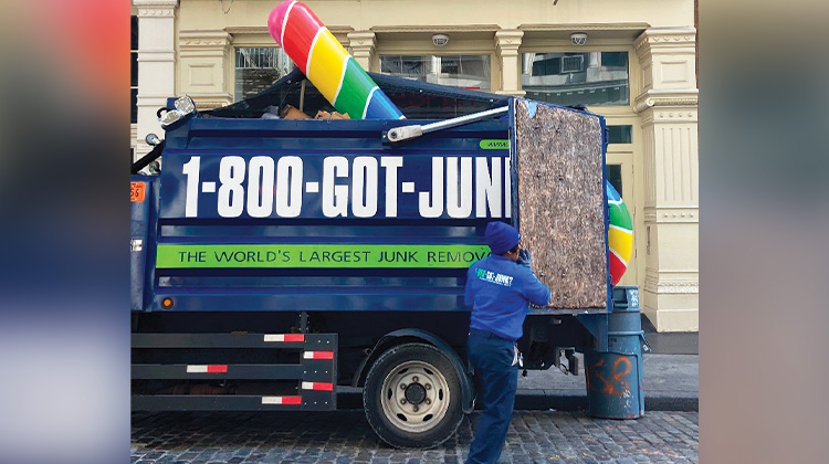 Gian candy cane loaded into the back of a 1-800-GOT-JUNK? truck