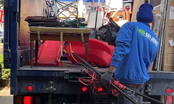 A 1-800-GOT-JUNK? Truck Team Member loading junk into the truck.